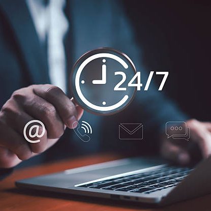 Businessman using laptop with 24/7 customer support icons including phone, email, chat, and internet communication symbol, representing online service, business technology, and digital assistance.
